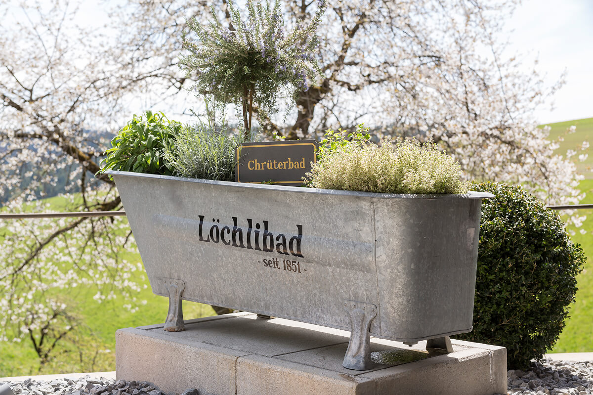 Alte Badewanne mit Kr&auml;utern als Brunnen, L&ouml;chlibad seit 1851